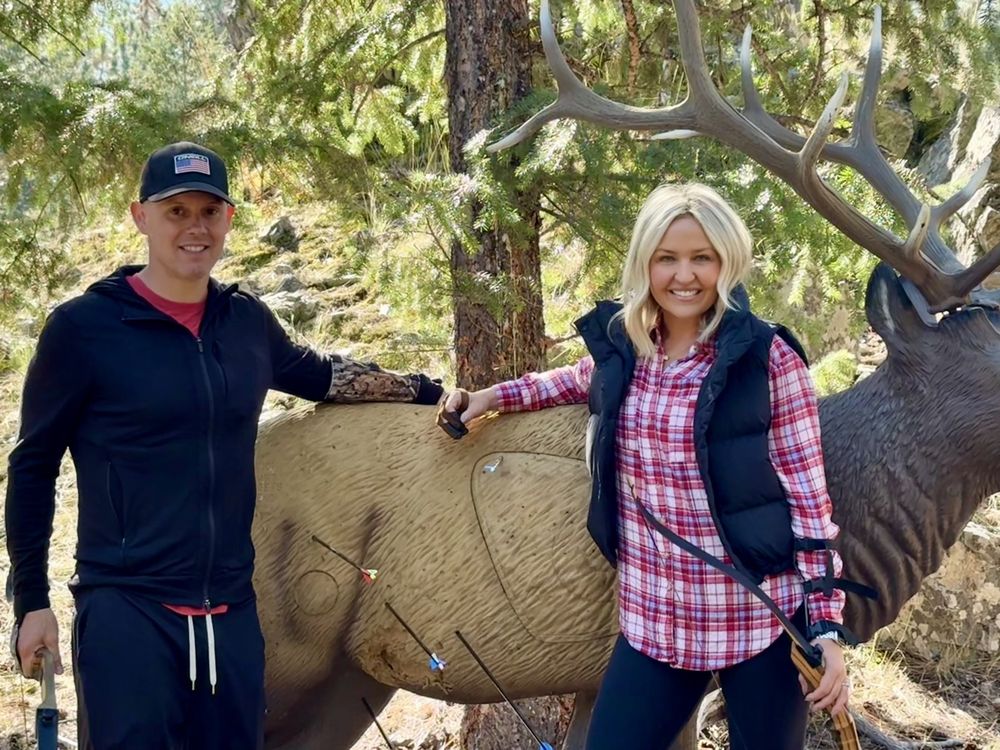 Adele and her husband next to an elk archery target